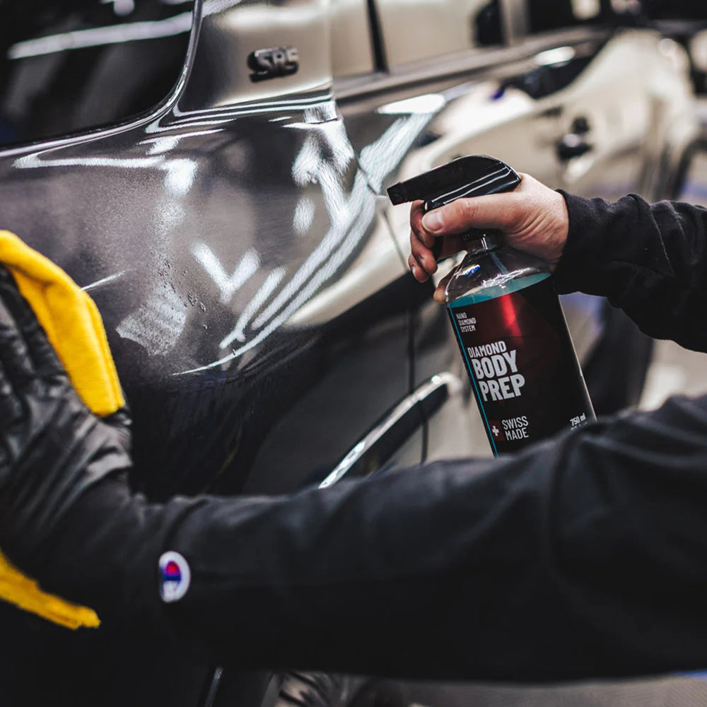 Man spraying Diamond ProTech Diamond Body Prep to prepare car surface for ceramic coating application.